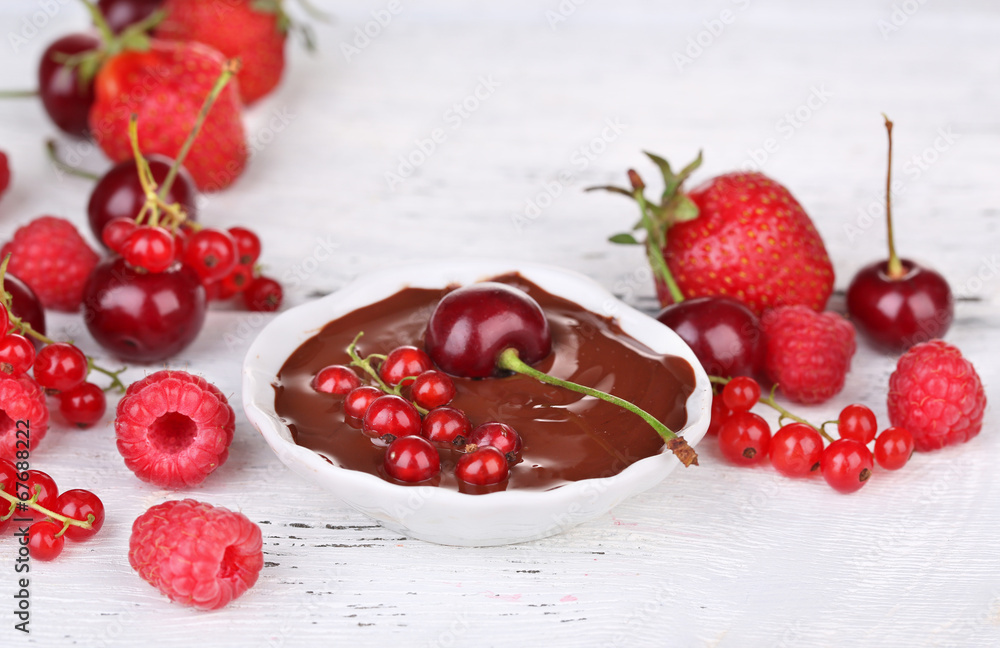 Ripe sweet berries and liquid chocolate on wooden table Ripe sweet berries and liquid chocolate on wooden table