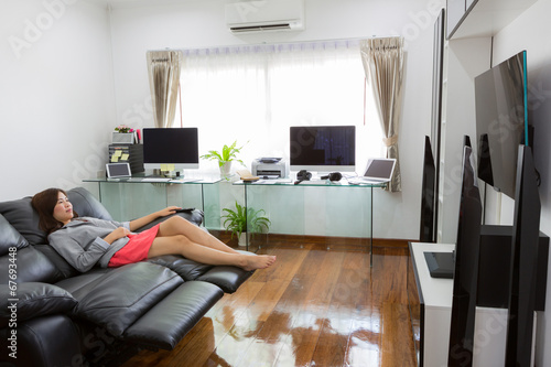 Business young woman watching TV in modern home office with comp