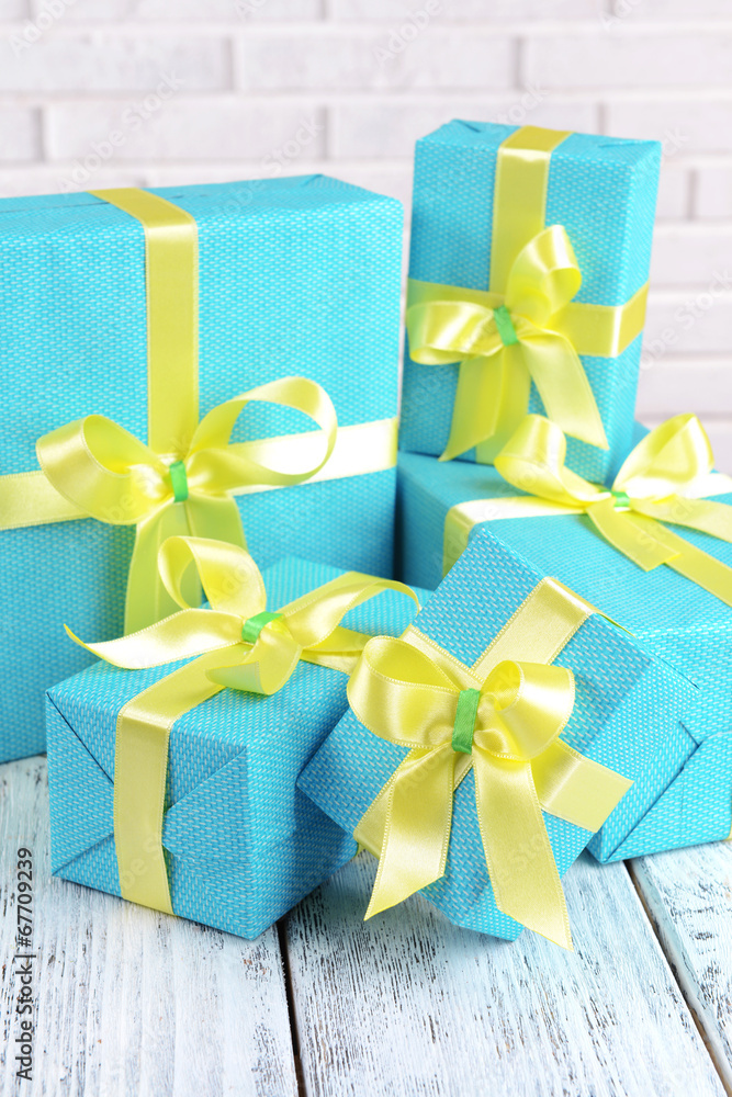 Beautiful gifts on table on brick wall background Beautiful gifts on table on brick wall background