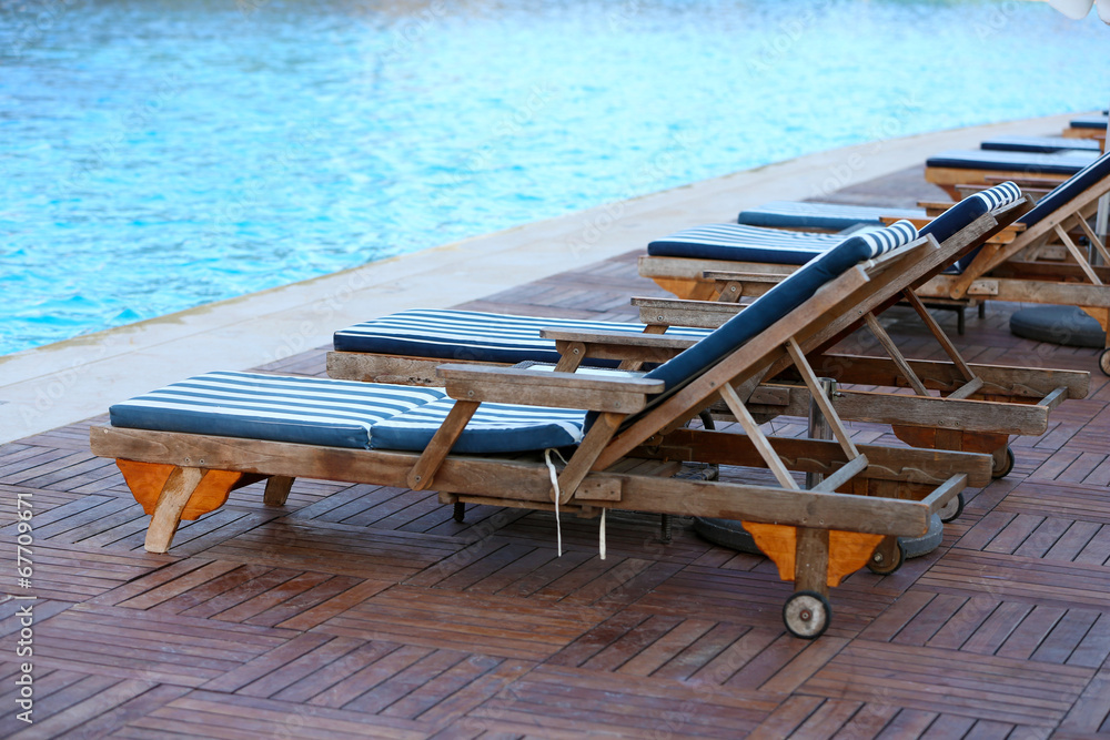 Fototapeta premium Lounge sunbeds near swimming pool