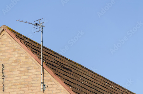 TV arial on roof of red brick house photo