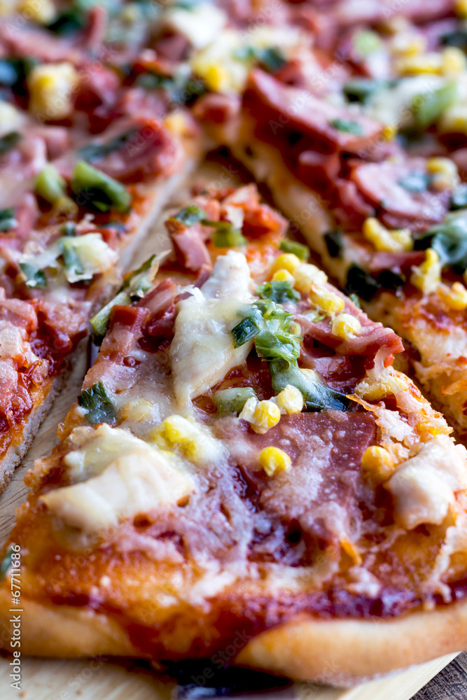 pizza with sausage, chicken, corn and cheese