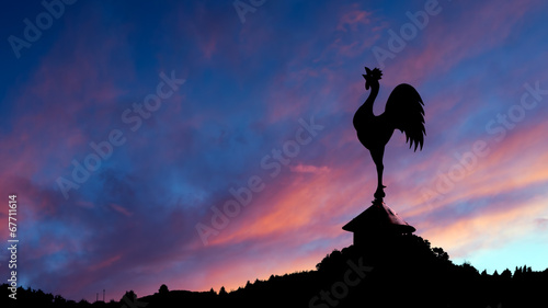 Spectacular dawn with cockerel weathervane and landscape. photo