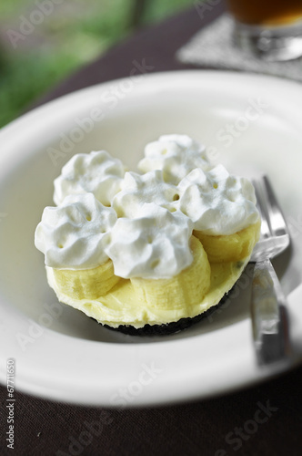 close up banana chocolate cake and cream in white dish