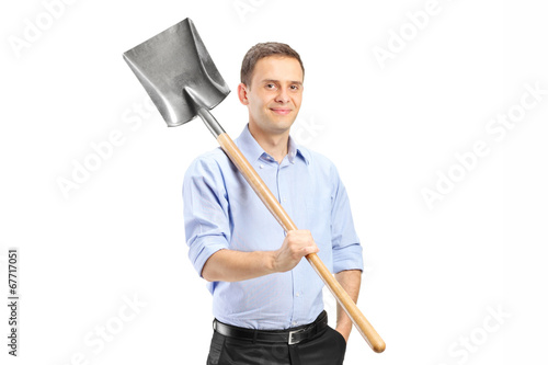 Young man posing with a shovel