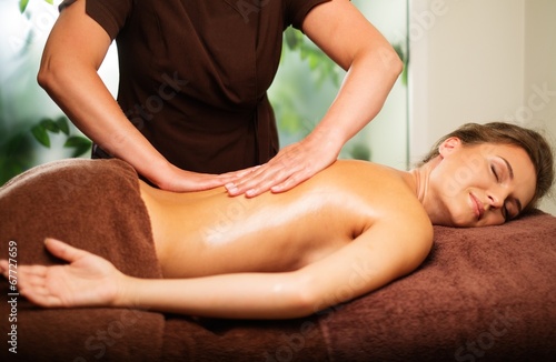 Beautiful young woman having massage in a spa salon