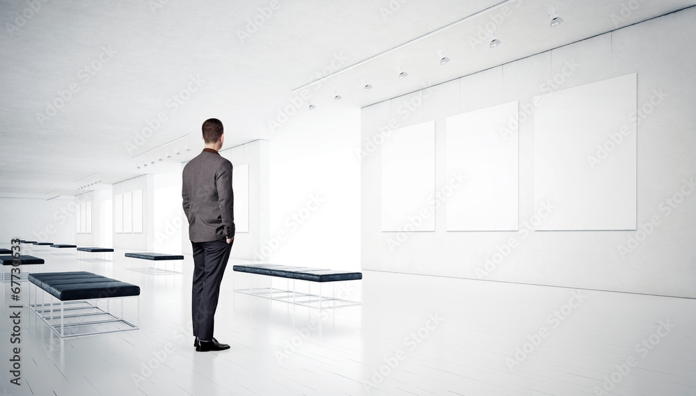 Gallery room and man looking at empty frames Gallery room and man looking at empty frames