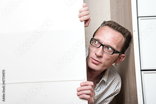 Canvastavla Surprised man inside white wardrobe  Copy space left