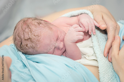 Young beautiful woman with a newborn baby after birth photo