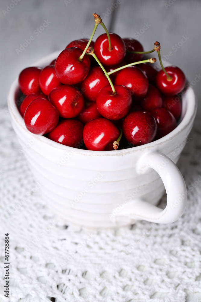 Sweet cherries in mug on wooden background Sweet cherries in mug on wooden background