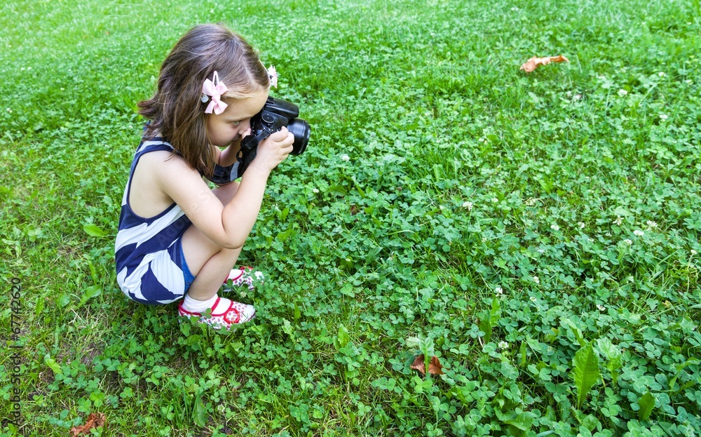 Girl who takes pictures with a photo camera in park Girl who takes pictures with a photo camera in park