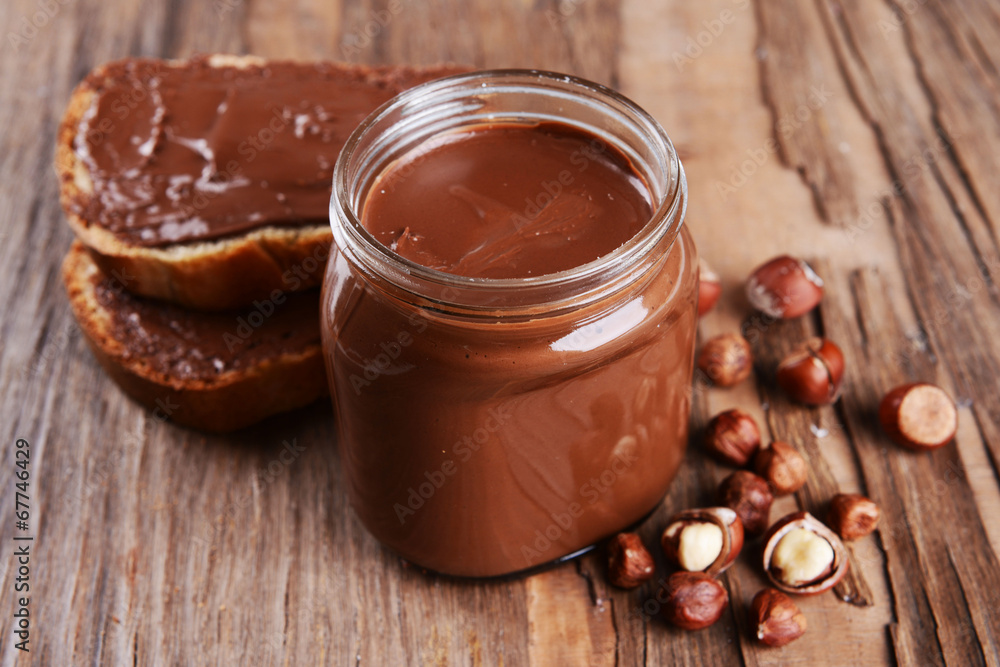 Sweet chocolate cream in jar on table close-up Sweet chocolate cream in jar on table close-up