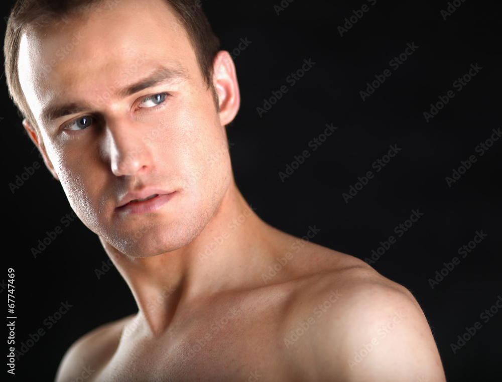 Portrait of a naked muscular man, isolated on black