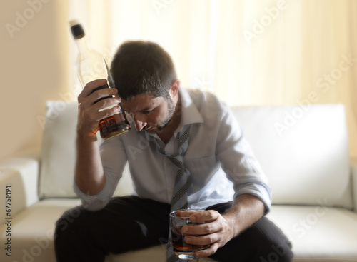 messy drunk businessman drinking alcohol at home photo