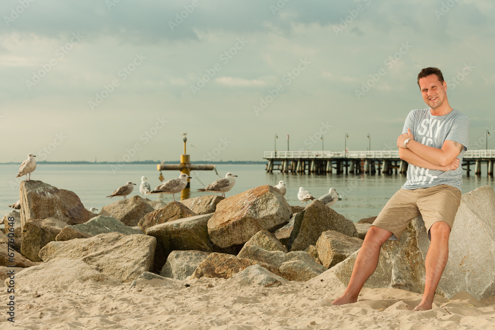 Fashion portrait of handsome man on the beach Fashion portrait of handsome man on the beach