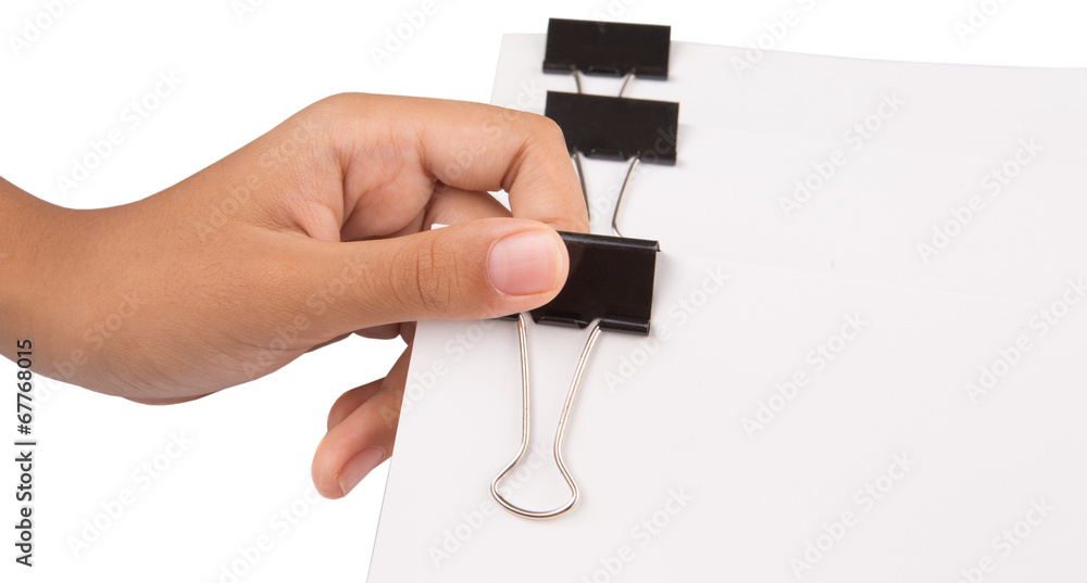 Female hand holding white paper with binder clips Female hand holding white paper with binder clips