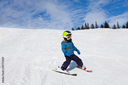 Boy in ski mask skiing on snow downhill