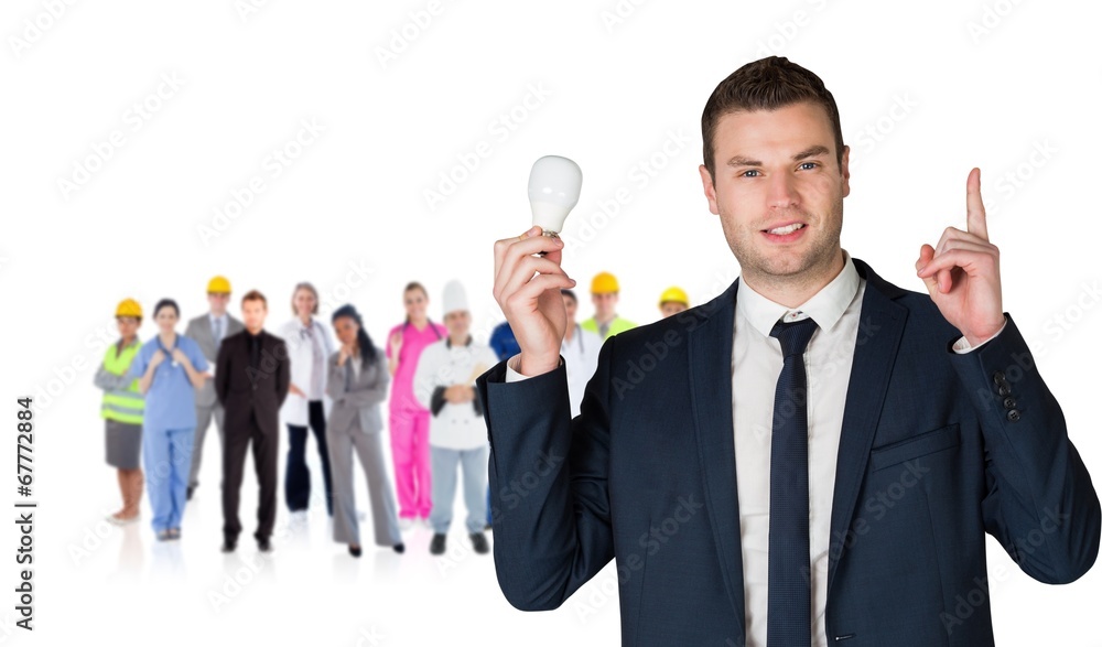 Composite image of businessman holding light bulb and pointing Composite image of businessman holding light bulb and pointing