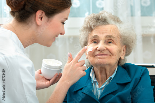 Elderly woman is assisted by nurse at home