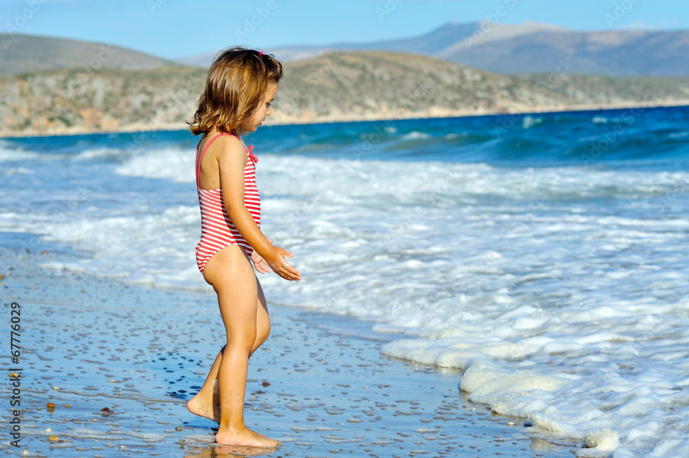 Naklejka premium Toddler girl at beach