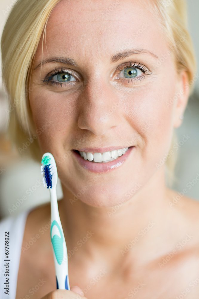 Beautiful young lady holding toothbrush and smiling Beautiful young lady holding toothbrush and smiling