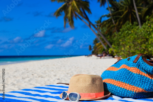 hat, bag, sun glasses on a tropical beach