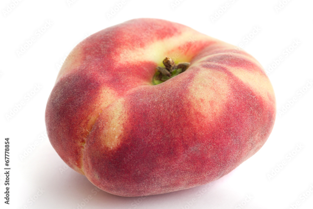 Single flat peach on white with selective focus. Single flat peach on white with selective focus.