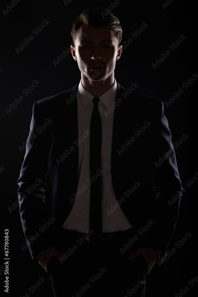 Fototapeta premium Handsome business man in black suite, backlight