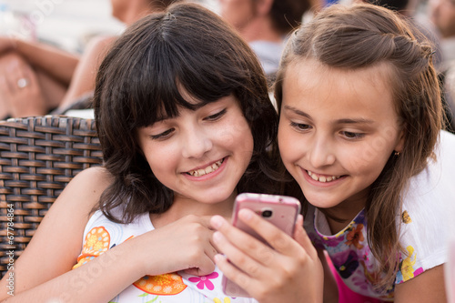 Two girls with smartphone smiling