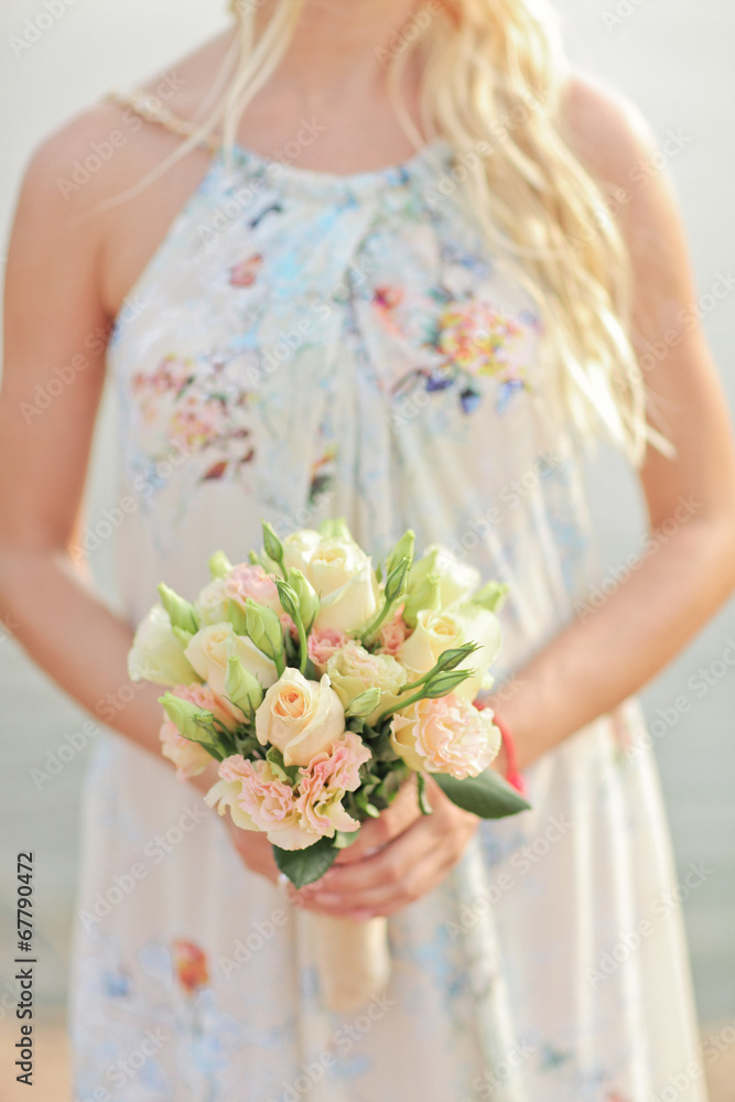 Beige and white wedding bouquet of roses in the hands of the bri Beige and white wedding bouquet of roses in the hands of the bri