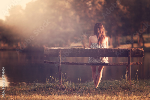 Girl sitting in a bench photo
