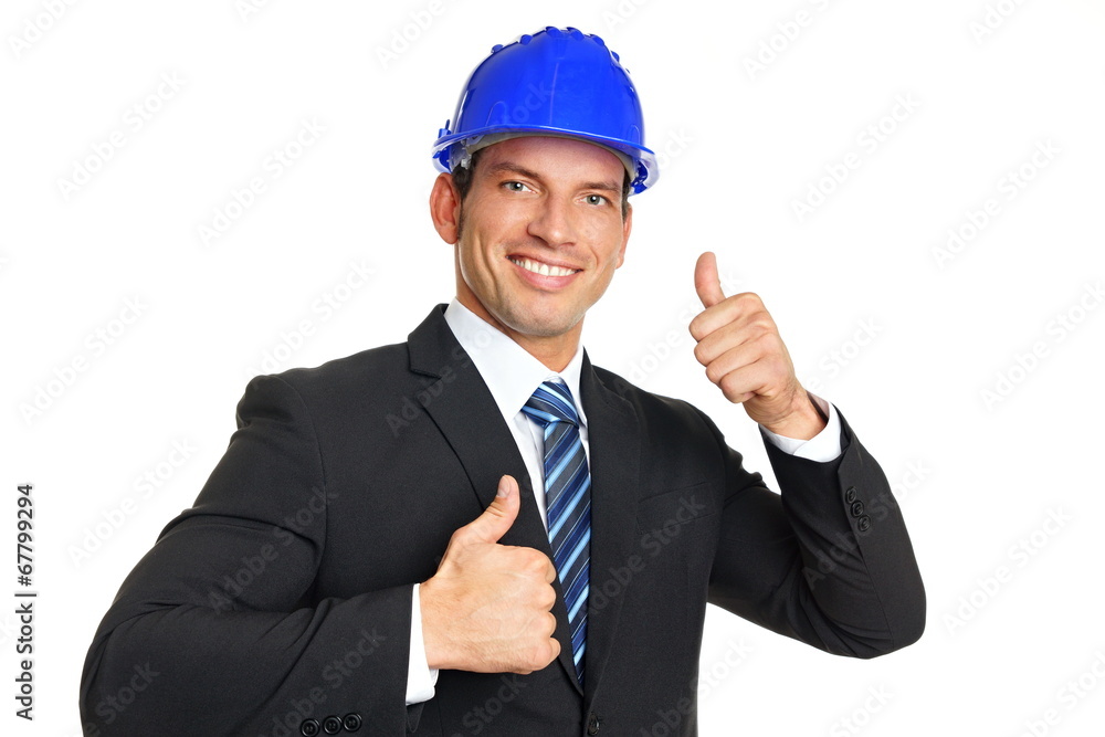 Smiling businessman in a protective helmet shows you thumbs up