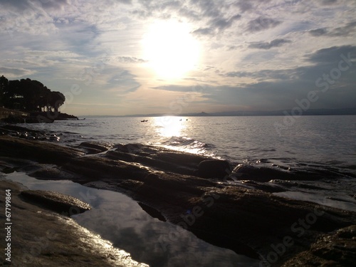 Riflessi sulle rocce levigate nella riva del lago photo