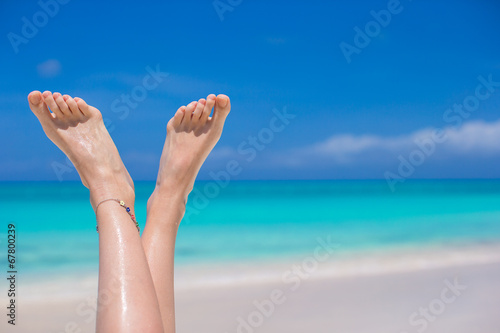 Close up of female feet on white sandy beach