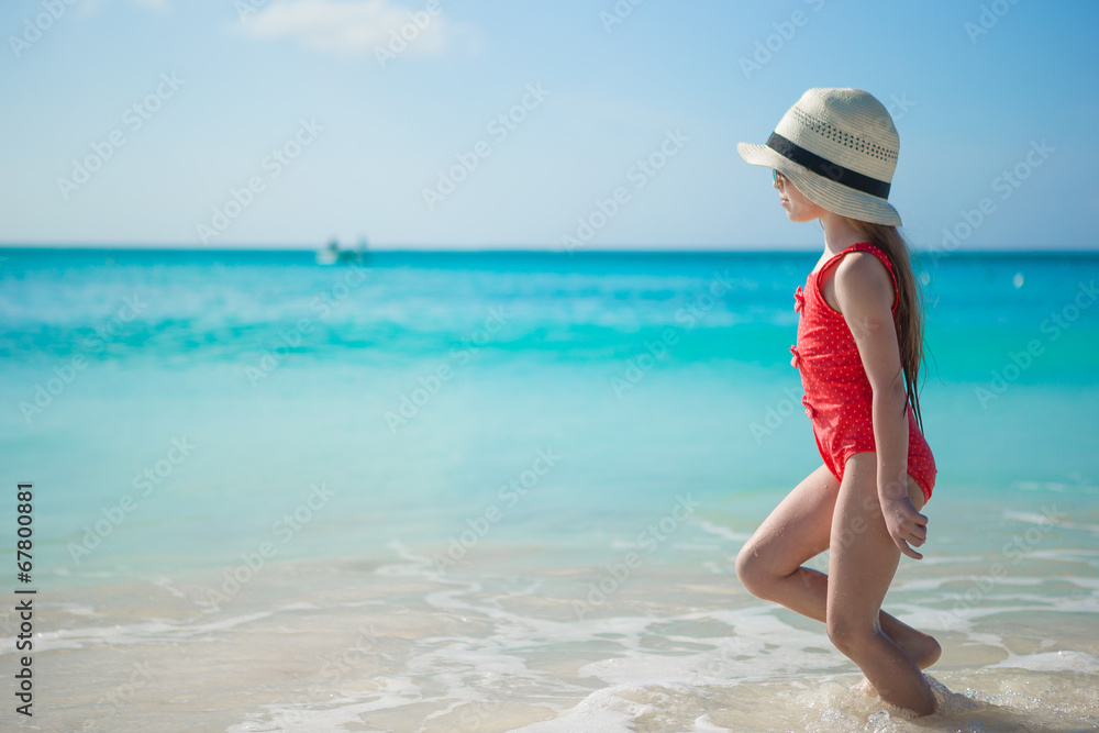 Cute little girl playing in shallow water at exotic beach Cute little girl playing in shallow water at exotic beach