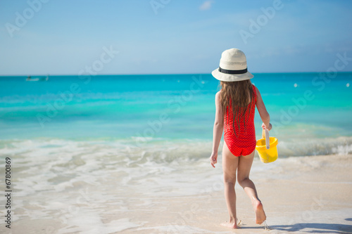 Happy little girl playing at beach during caribbean vacation