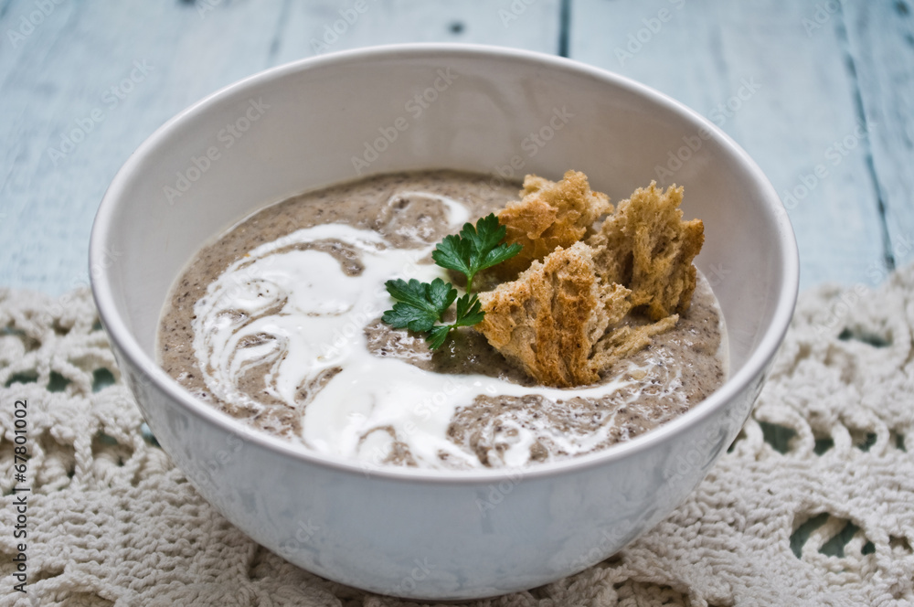 Bowl with cream of mushroom soup on a wooden table Bowl with cream of mushroom soup on a wooden table