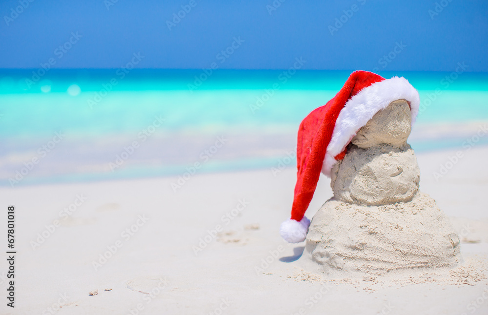 Little sandy snowman with red Santa Hat on white Caribbean beach Little sandy snowman with red Santa Hat on white Caribbean beach