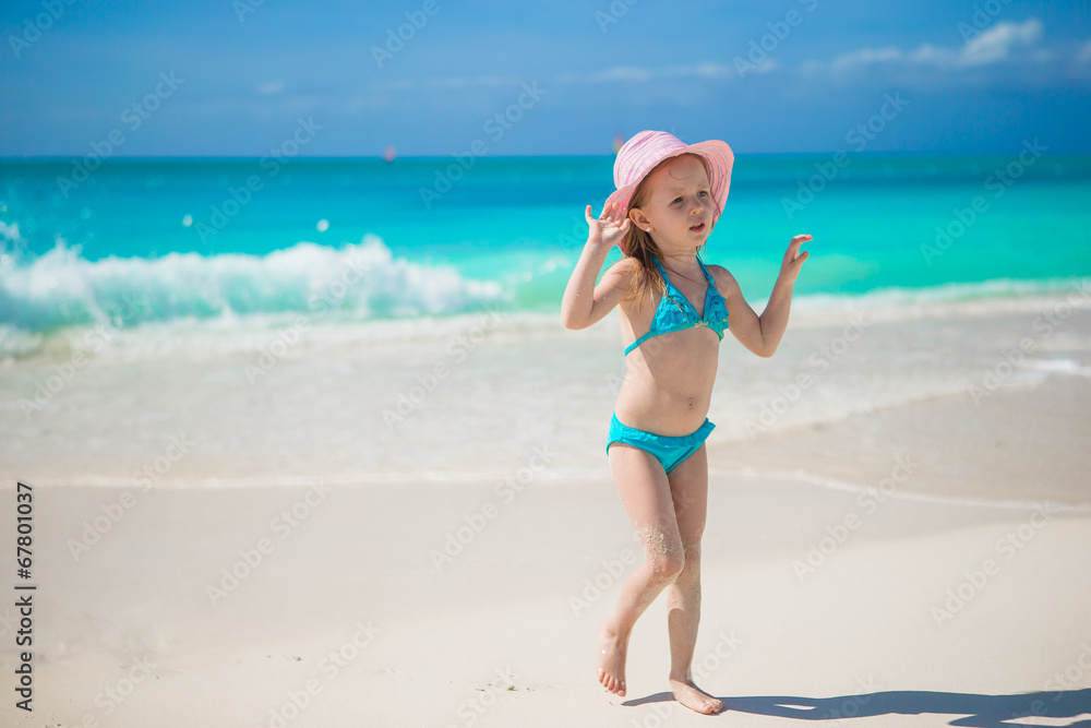 Adorable little girl in hat at beach during caribbean vacation