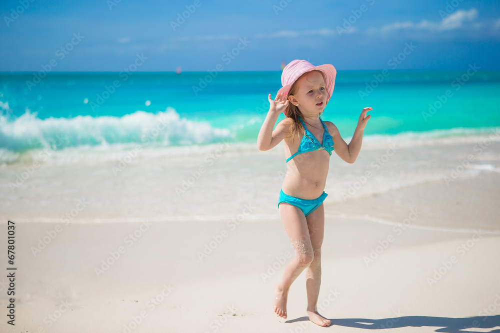 Adorable little girl in hat at beach during caribbean vacation Adorable little girl in hat at beach during caribbean vacation