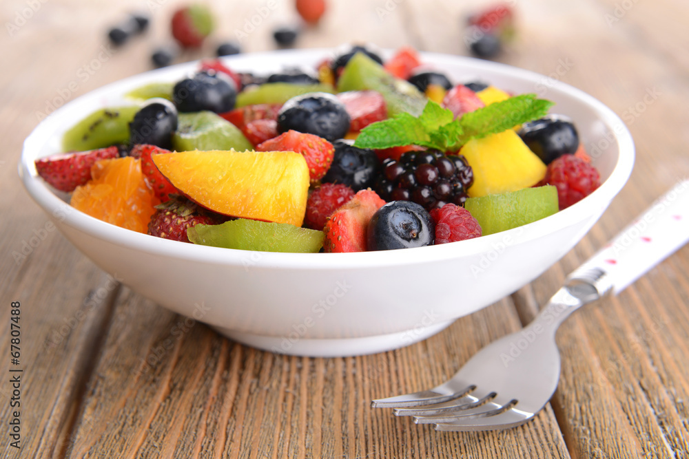 Delicious fruits salad in plate on table close-up Delicious fruits salad in plate on table close-up