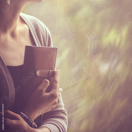background girl sitting and looking out the window and holding a
