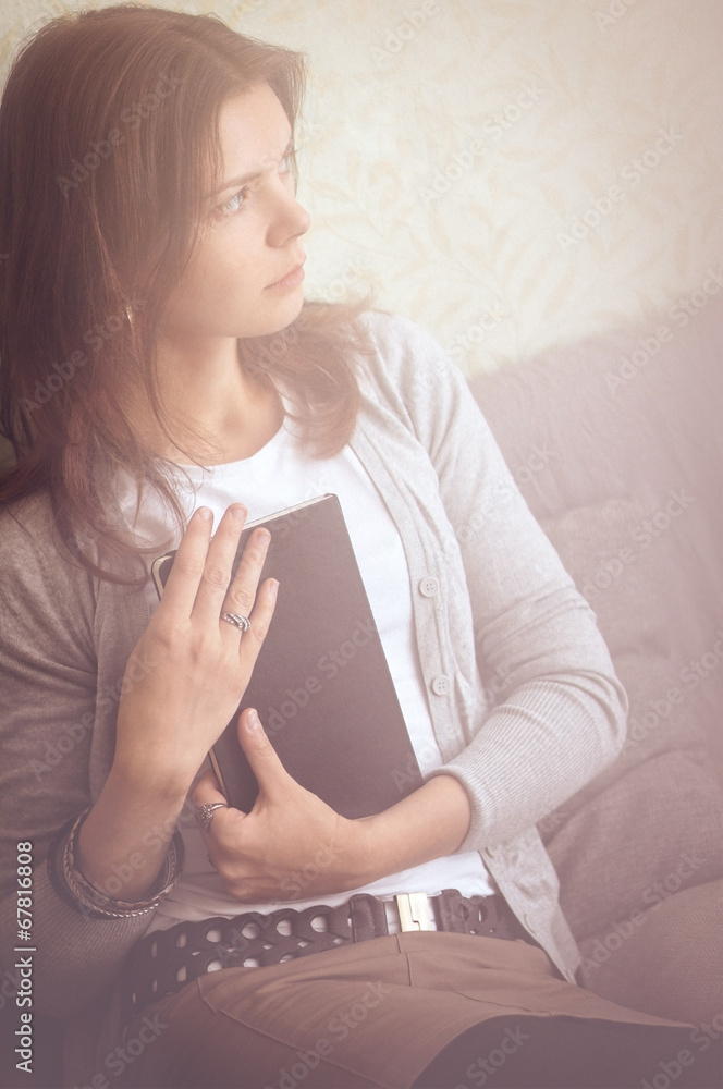 gray-brown tones background girl sitting on a couch relaxing ind gray-brown tones background girl sitting on a couch relaxing ind