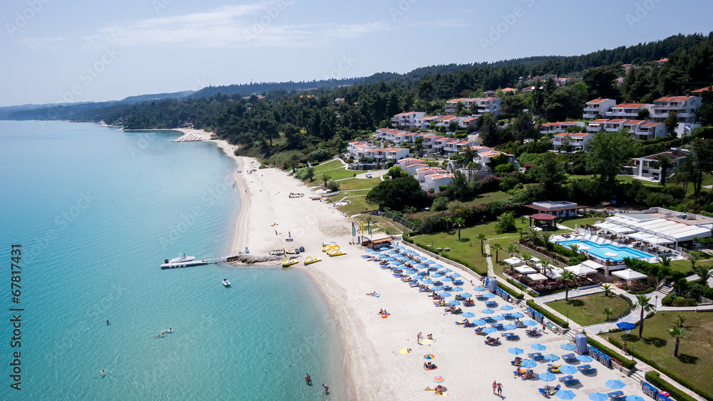 Top view of beach with tourists, sunbeds and umbrellas at a luxu