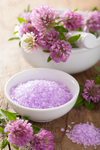 spa with purple herbal salt and clover flowers