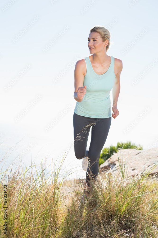 Fit blonde jogging on mountain trail Fit blonde jogging on mountain trail