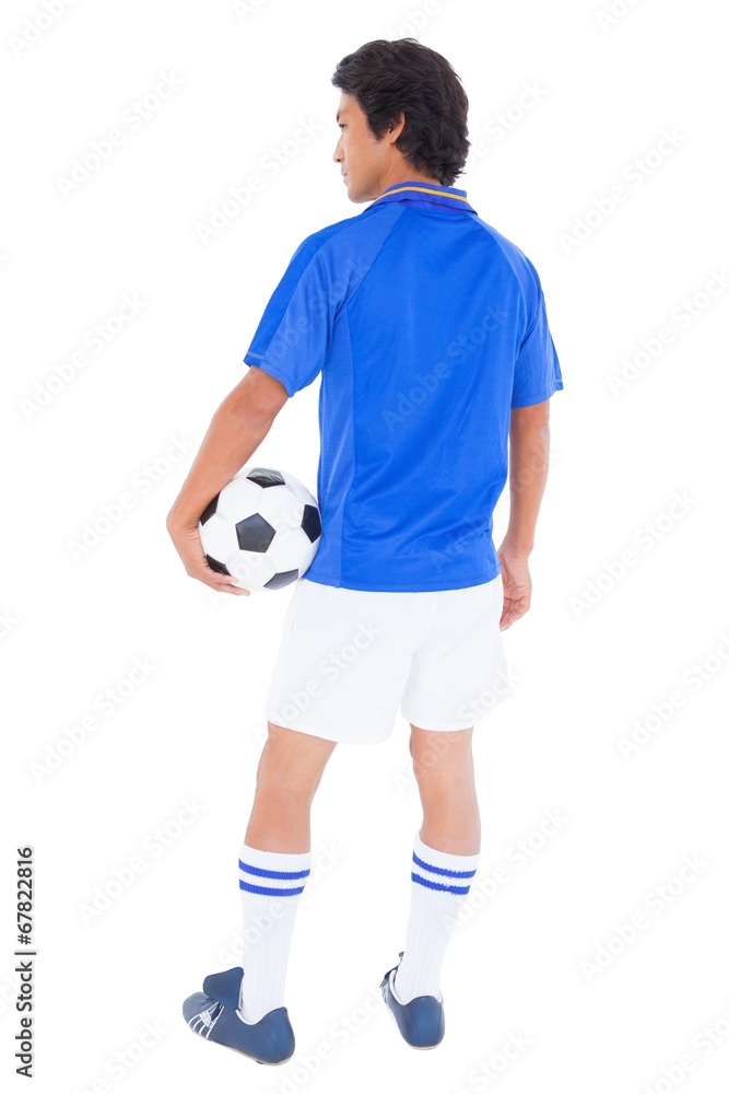 Football player in blue holding the ball Football player in blue holding the ball