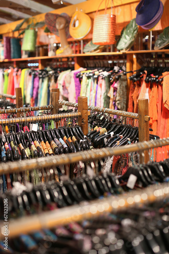 A rack of colorful shirts hanged for sale at a fair