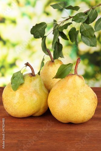 Juicy pears on table on bright background