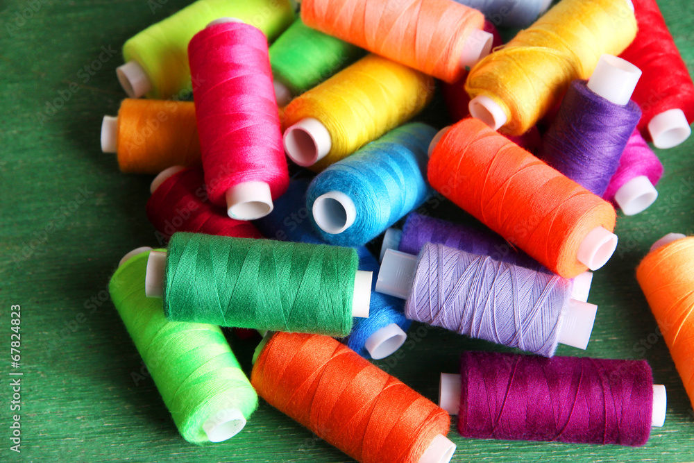 Multicolor sewing threads on wooden background Multicolor sewing threads on wooden background